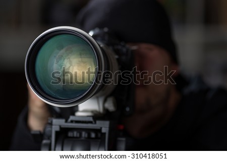 Man taking pictures of cheaters with a large telephoto lens