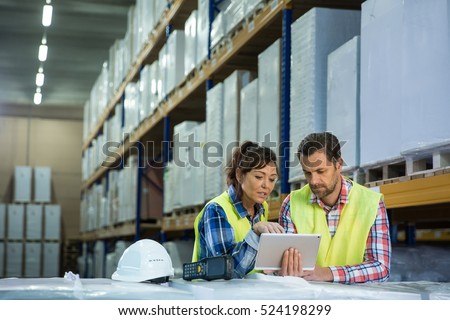 Man and a woman have short meeting in a warehouse on checking inventory levels of goods. First in first out, Last in last out, team working together concept photo.