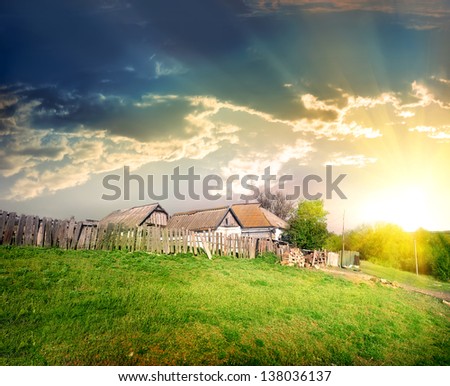 Old village house on the background of thunder clouds
