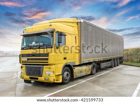 Yellow truck on road. Cargo transportation
