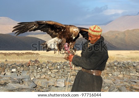 MONGOLIA - 25 JULY: The senior Mongolian horseman in traditional clothing with golden eagle during the festival of name \