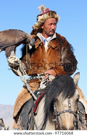 MONGOLIA - 25 JULY: The senior Mongolian horseman in traditional clothing with golden eagle during the festival of name \