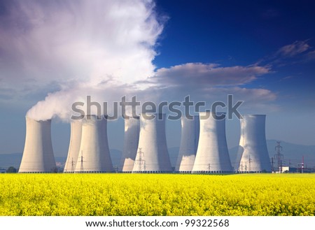 Nuclear power plant with yellow field and big blue clouds.