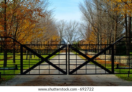 A closed gate hides a long driveway to a country estate