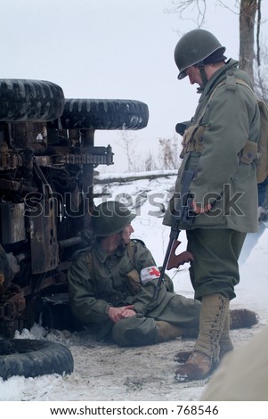 WWII Soldiers in a winter setting. (next to an over turned jeep)