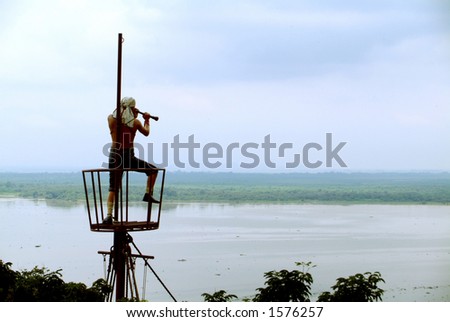 A pirate looks out on to the water from a bird\'s nest
