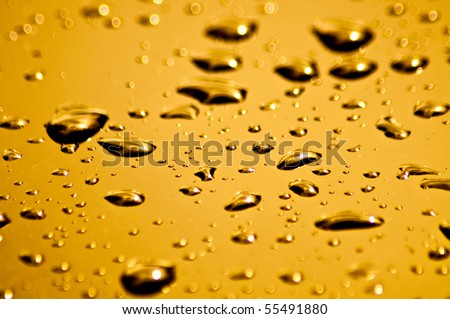 Bright orange and yellow water droplets on the hood of a car