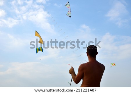man playing with kite on the beach