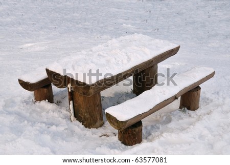 table into the park covered by snow