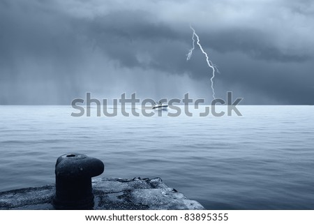 motorboat in the sea with stormy sky with lightning