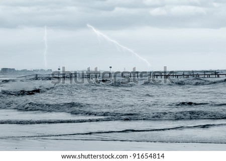 bad weather in winter on the sea with lightning at horizon