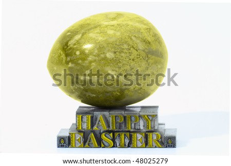 Happy easter in letterpress type and marble egg isolated on a white background.