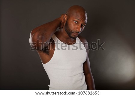 Young, handsome, muscular black man in a t-shirt with hand on his neck