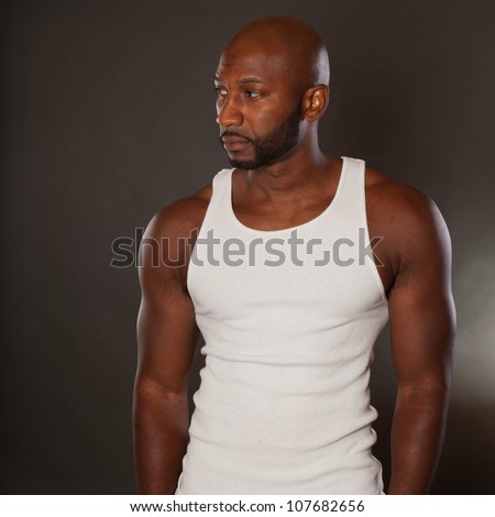 Young, handsome, muscular black man in a t-shirt looking away
