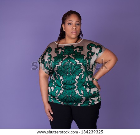 Beautiful plus size black woman standing on a purple background