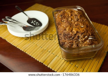Sweet bread in the baking pan ready to be sliced and served with plates in the background
