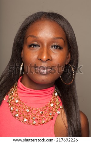 Fashion forward African American woman with part American Indian heritage in a pink dress with jewelry