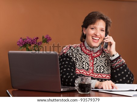 Work From Home - Attractive woman working/shopping from home wearing a winter sweater with a cup of black coffee