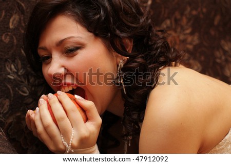 beautiful young girl-bride bites fruit