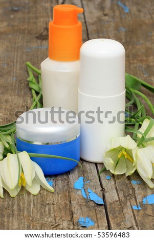 spa cosmetic bottle and flower on the background of a wooden board