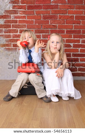 Little boy talking on  phone,  girl is bored. Relationship. Series