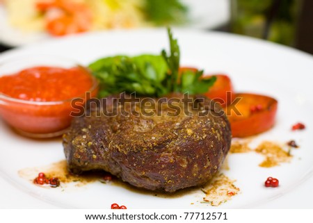 Grilled steak, sauce and tomatoes (shallow depth of field)