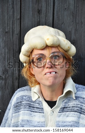 Confused woman with pumpkin on her head