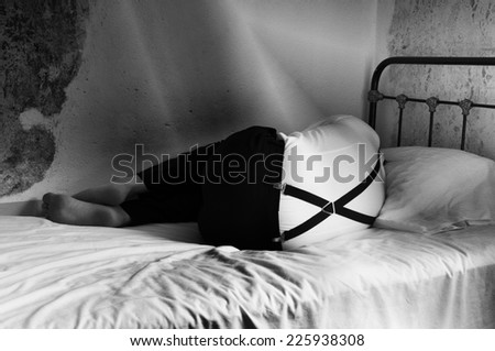 Artistic textured black and white picture of sad man in a bed.