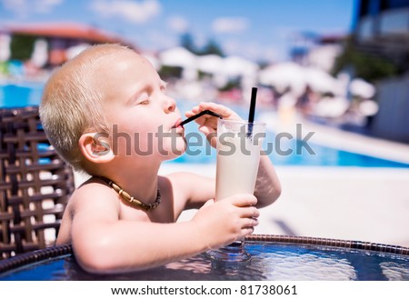 Little boy drinking his cocktail in the pool bar