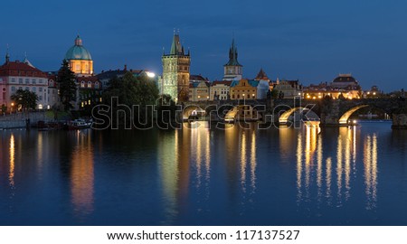 Prague, Evening view of the Charles Bridge with Old Town bridge tower and Dome of the church of Saint Francis of Assisi, Czech Republic
