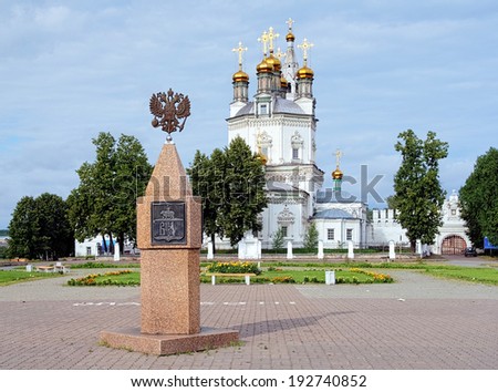 VERKHOTURYE, RUSSIA - JULY 22, 2012: Monument with Coat of arms of Verkhoturye and Trinity cathedral. The monument was unveiled in 1997 to commemorate the 400th anniversary of the city.