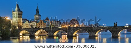 Evening panorama of the Charles Bridge in Prague, Czech Republic, with Old Town Bridge Tower, Old Town Water Tower and dome of the National Theatre