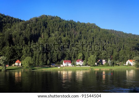 Shore of the Elbe River with small houses in Saxon Switzerland, Germany