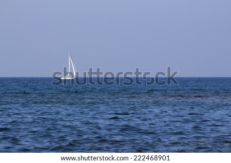 Sailing boat on the open blue sea at the sunset.