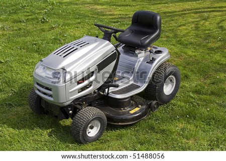Small tractor for cutting grass. All logos removed. Warning signs left.