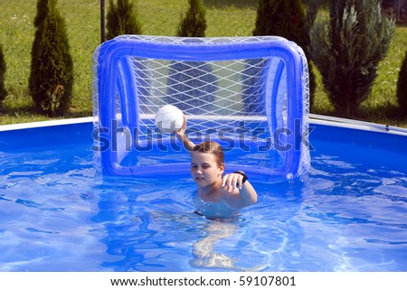 Teenager playing water polo in garden pool.