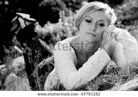 Young woman lying in the grass on a hot spring day, day dreaming about something.