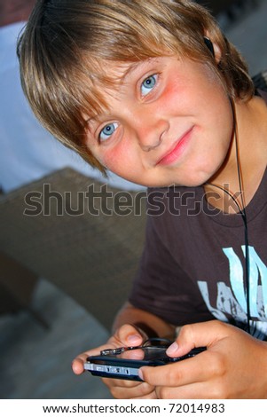 Teen boy playing video games with portable device.
