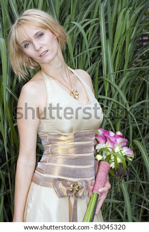 Bride in golden dress holding a boquet