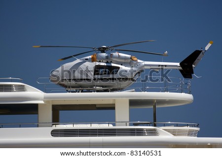 Silver helicopter on the deck of the yacht.