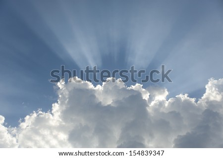 The sunshine streaming from a cloud.