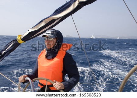 The captain controls the yacht on a regatta in the Aegean Sea.