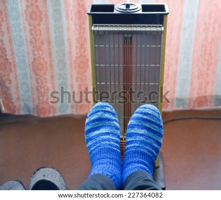 Warming of feet a heater with a quartz lamp in the cold room
