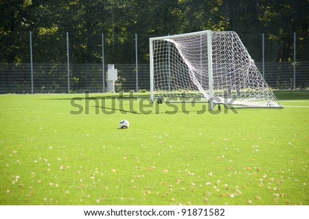 Football. A ball on a grass and football gate.