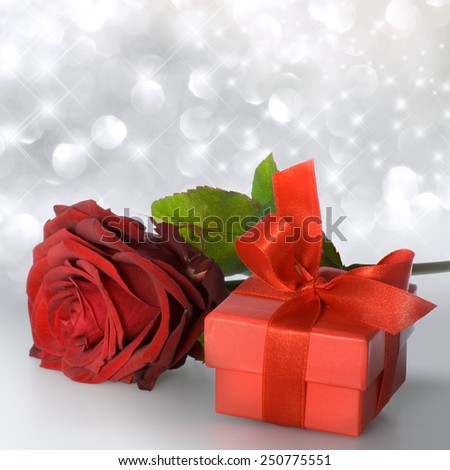 Red rose with red gift package on silver bachground