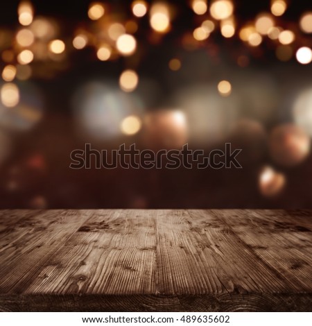Dark abstract background with christmas lights in front of a  table