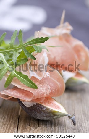 Figs with parma ham and rocket on wood plate