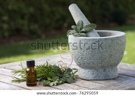 Drip bottle, pestle and mortar, with fresh foliage in the background
