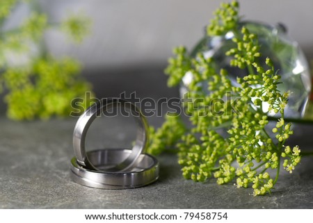 stock photo Wedding rings in silver on a slate with flowers
