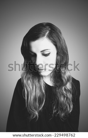 Black and white portrait of a sad woman dressed in vintage style